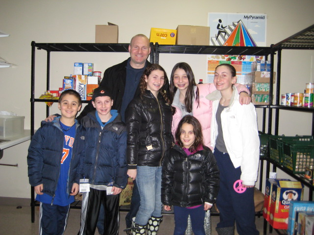 Danielle and the rest of the Klausner family in front of the results of her bat mitzvah project.