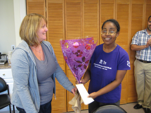 Doreen, our Administrative Coordinator, presents Roxie with a bouquet of flowers.