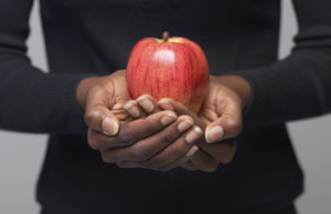 A woman holding a healthy apple